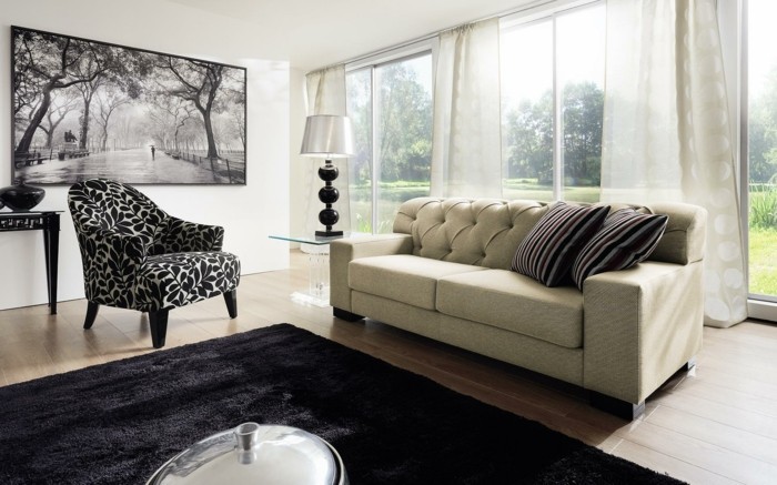 moderne-sessel-in-schwarz-und-weiss-pflanzenmotive-weisse-couch-schwarzer-plueschteppich-glastisch-lange-transparante-gardinen-fenster-bis-zum-boden