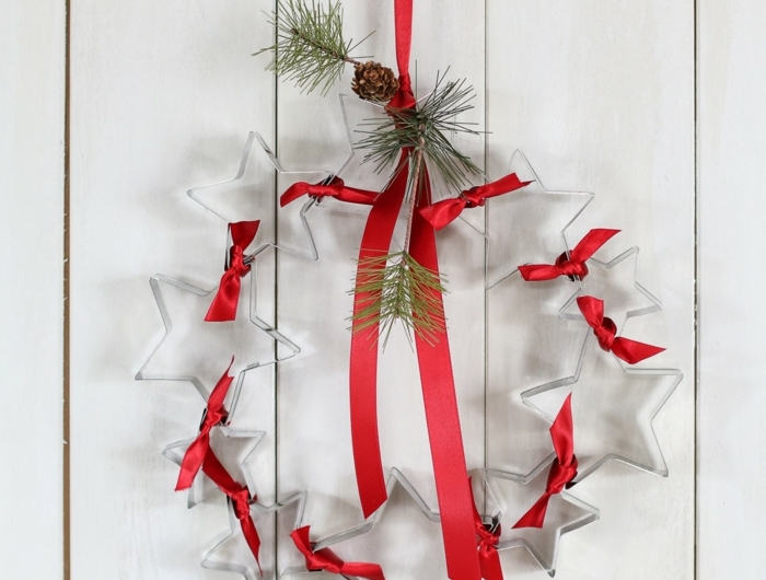 originelle bastelideen weihnachtskranz basteln aus ausstechformen in sternform dekoriert mit rotem band tannenzweigen und tannenzapfen