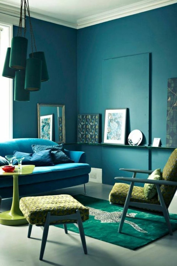 wandfarbe-blau-teppich-tuerkisgruen-polsterhocker-polstersessel-blaue-couch-spiegel