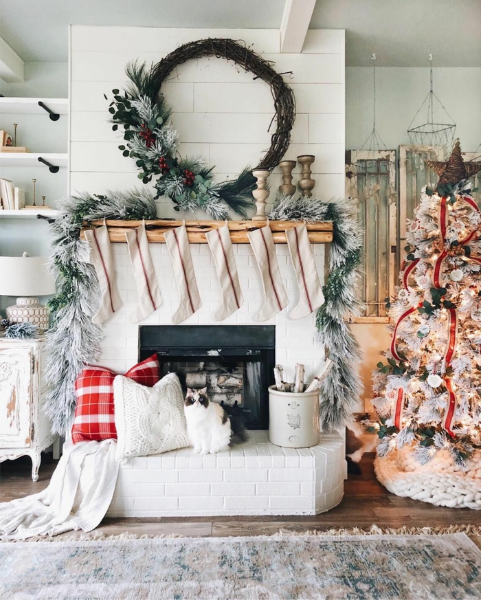 wohnzimmer dekorieren weihnachten weißer dekorierter tannenbaum nikolausstiefel am kamin weihnachtskranz selber machen