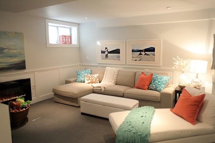 farbgestaltung-wohnzimmer-creme-eckcouch-weisser-relax-stuhl-orange-kissen-blaue-musterkissen-blaue-schlafdecke-feuerstelle-kleines-fenster-leinwandbild