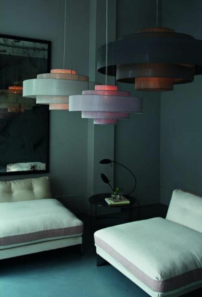wohnzimmer-farbgestaltung-farbige-waende-komfortable-weie-couch-runder-schwarzer-tisch-tischdeko-moderne-runde-kronleuchter-spiegel