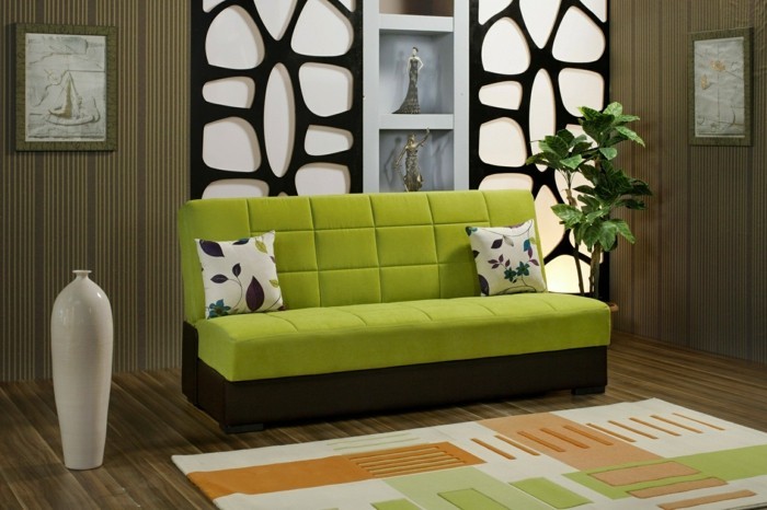 2farbgestaltung-wohnzimmer-gruene-couch-bunter-teppich-holzboden-dekorative-vase-dekorative-wandnischen-pflanze-kissen-mit-musterbezug