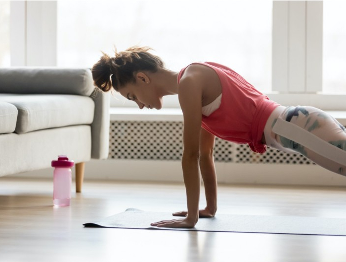 sportive girl doing push press ups exercise at home