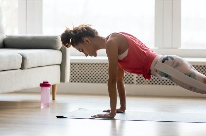 sportive girl doing push press ups exercise at home