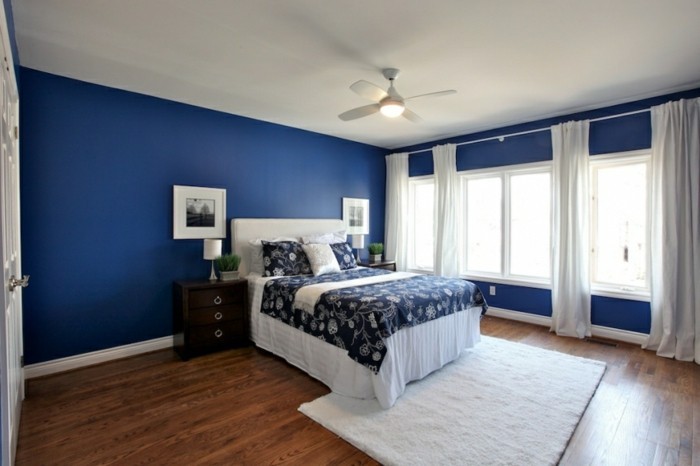 feng-shi-schlafzimmer-design-blau-dunkel-doppelbett-weisse-lacken-weisser-plueschteppich-holzboden-pflanzen-lange-gardinen-weisse-tuer