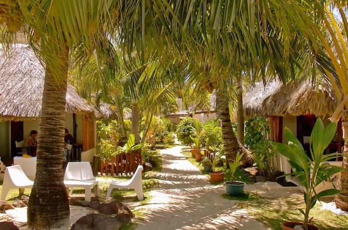 hotel mit privatem strand auf insel bora bora schöne grüne pflanzen palmen alee liegestühle häuschen