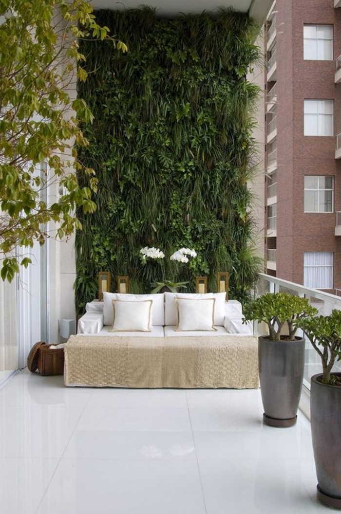 balkon-ideen-weiße-fliesen-sofa-kissen-grüne-pflanzen-wanddeko-blumen