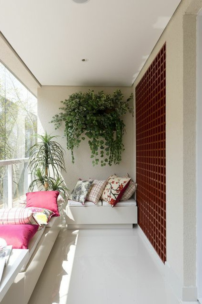 14-balkongestaltung-grüne-pflanzen-dekokissen-weißer-sofa-fliesen-fenster