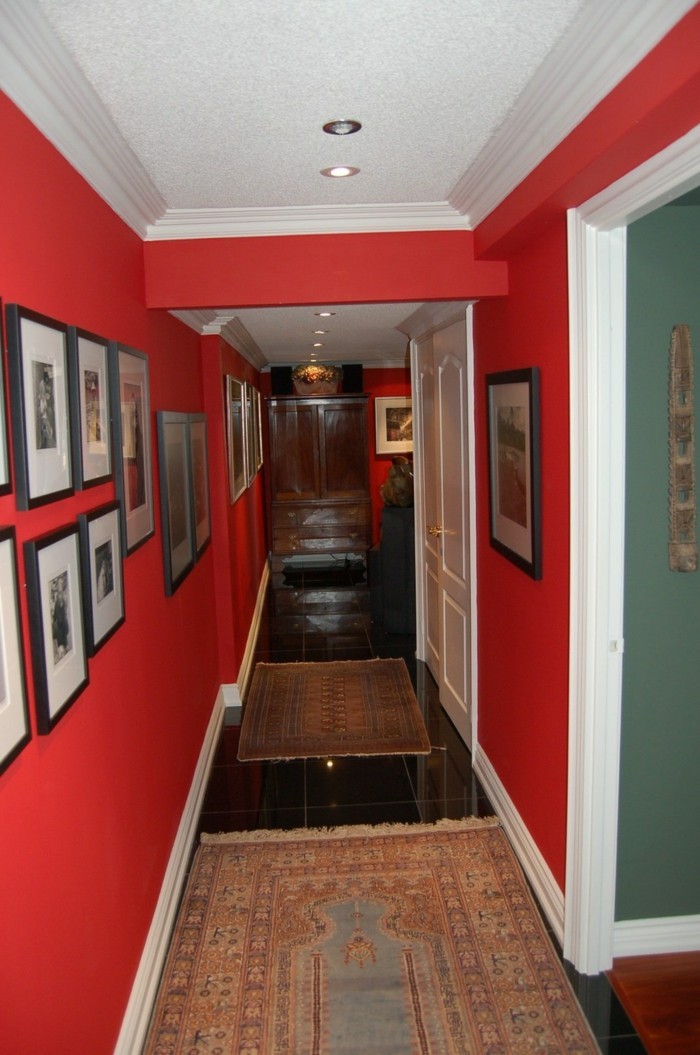Langen-Flur-gestalten-mit-roten-wänden-und-bilder-entlang