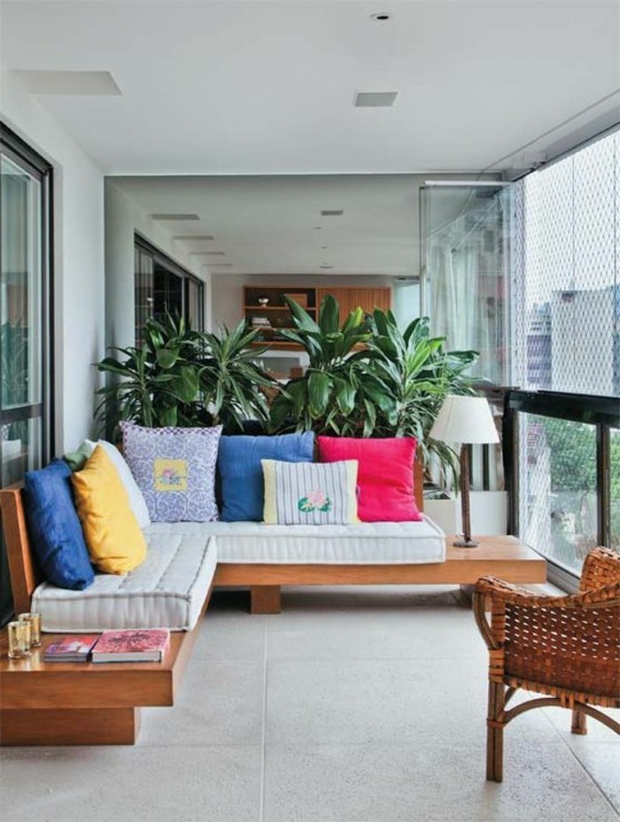 balkon-deko-grüne-pflanzen-sessel-sofa-dekokissen-fliesen-bücher-lampe