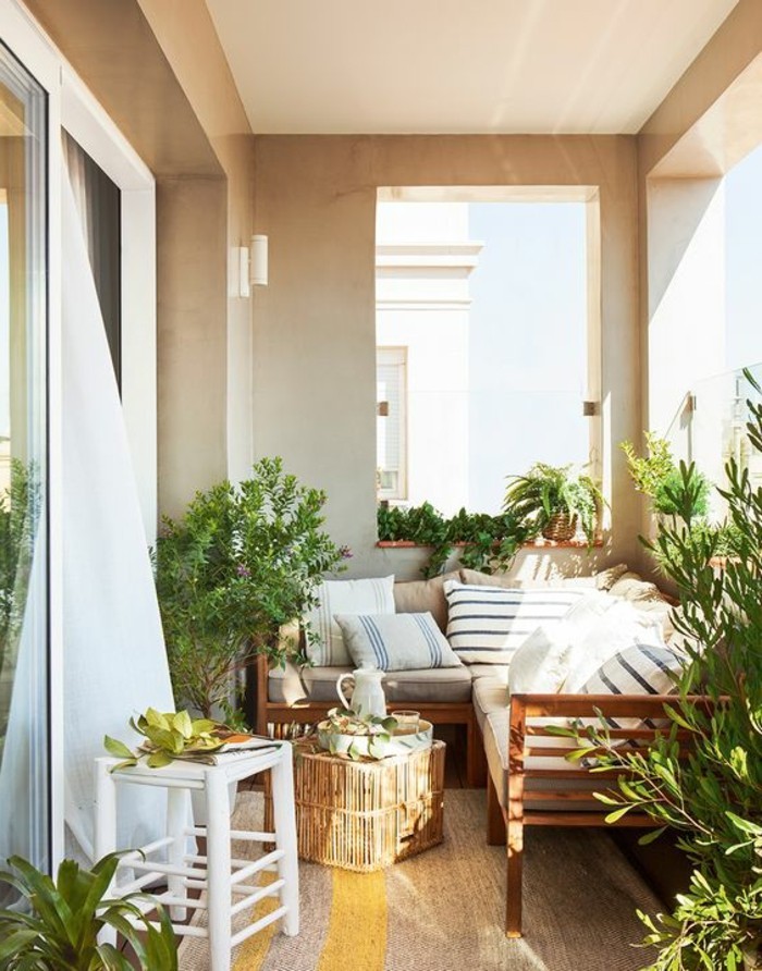 balkonideen-viele-grüne-pflanzen-sofa-kleiner-runder-tisch-weißer-hocker-gardinen