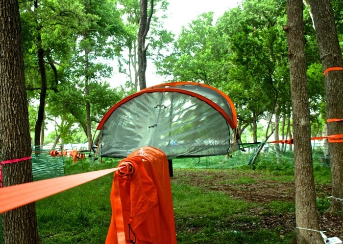 ein-oranges-campingzelt-im-grünen-wald