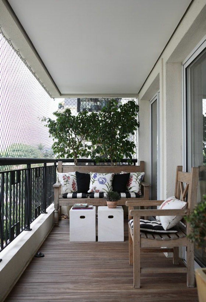 ideen-kleiner-balkon-boden-aus-holz-stuhl-sofa-kleine-weiße-tische-baum-pflanzen