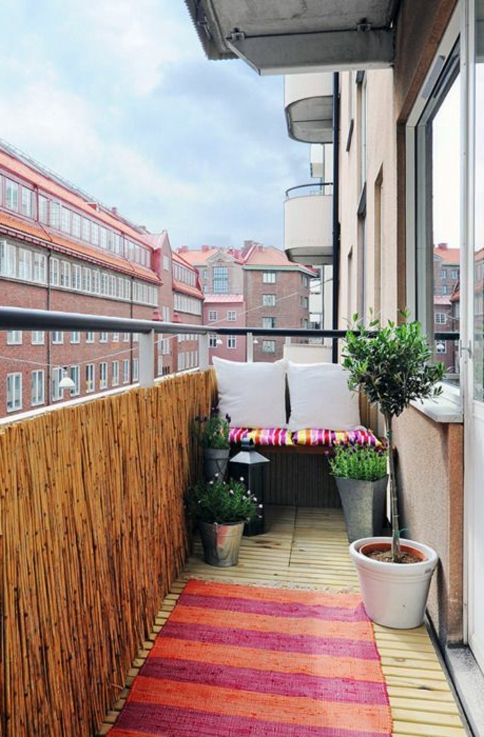 ideen-kleiner-balkon-grüne-pflanzen-retro-teppich-in-rosa-und-orange-kleiner-sofa