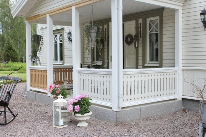 weißes-holzhaus-mit-veranda-gartendeko-landhausstil