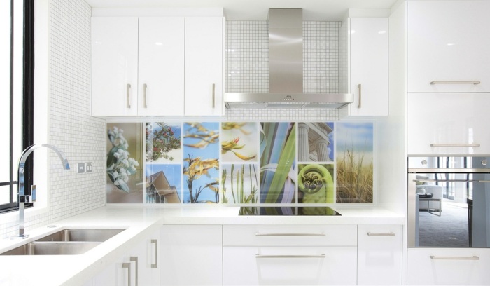 eine weiße küche mit buntem küchenrückwand als akzent