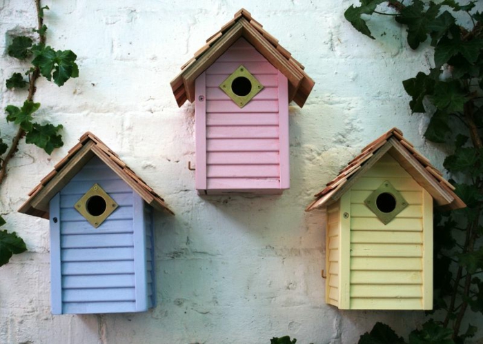 Vogelhäuser in blauer, pinker und gelber Farbe
