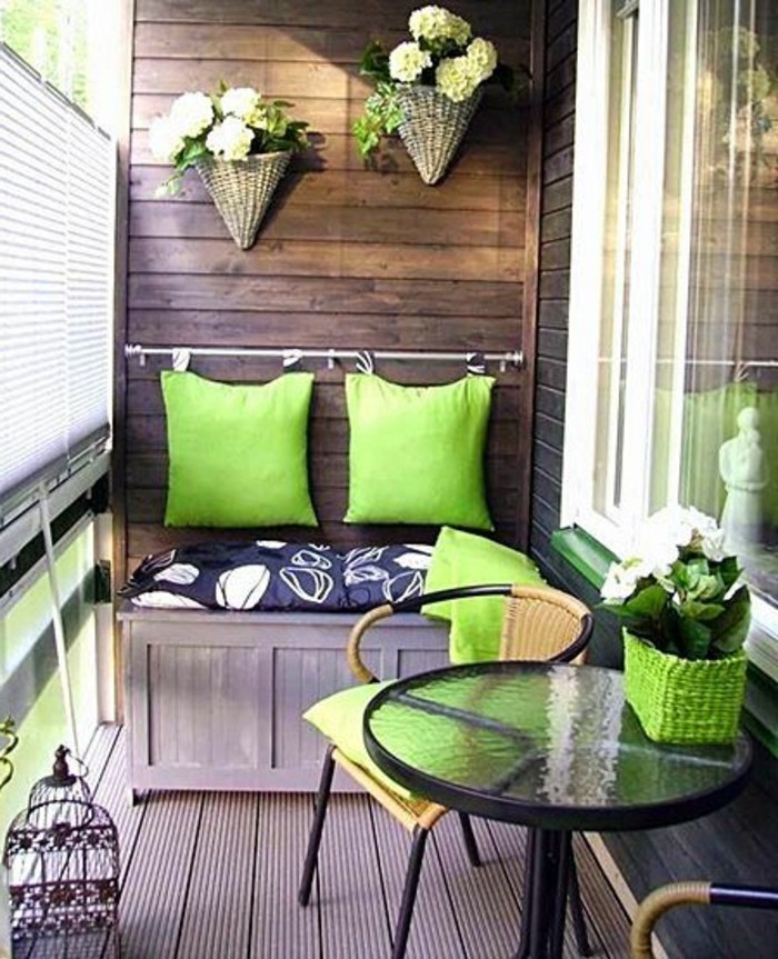 4kleine-räume-geschickt-einrichten-balkon-verglasen-grüne-kissen-holzboden-glastisch.flechtstühle-holzewand