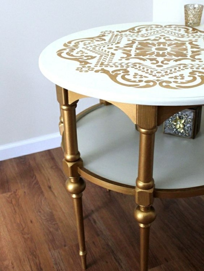 Alte-Möbel-aufpeppen-weißer-tisch-mit-goldenen-beinen-und-ornamenten-hölzerner-boden 