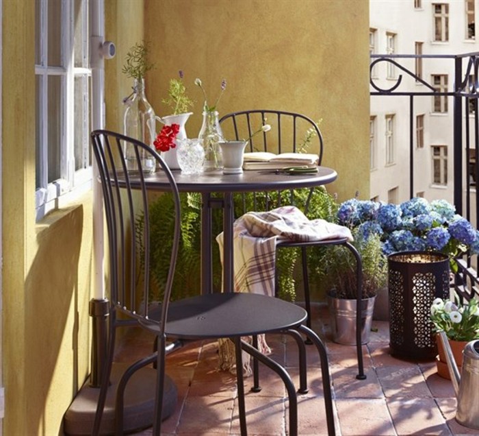 balkongestaltung-braune-bodenfliesen-metallstühle-schlafdecke-tischdeko-pflanzen-vasen-blumen