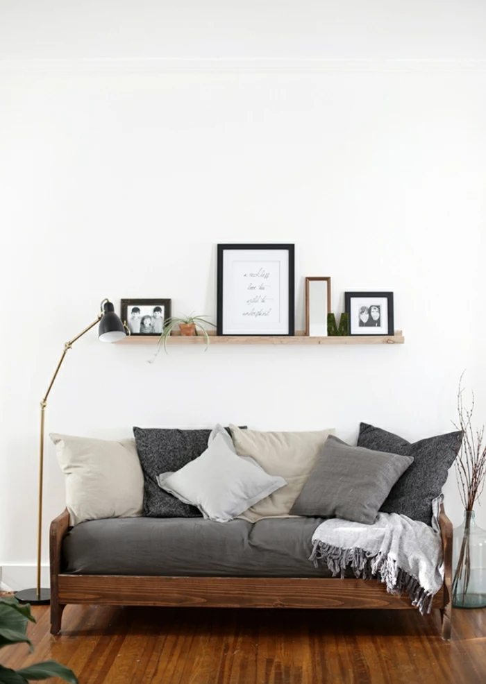 Sofa in grauer Farbe, einfarbige Kissen - Bilderleiste mit winzigem Blumentopf