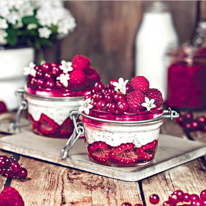 Smoothie in Glas, Rezept mit Himbeeren, Johannisbeeren und Drachenfrucht, mit essbaren Blüten dekoriert