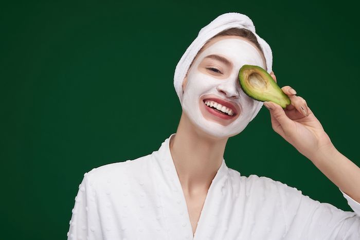 feuchtigkeitsmaske peel off maske selber machen anti pickel maske gesicht selber machen frau mit weißer maske hält avocado im hand