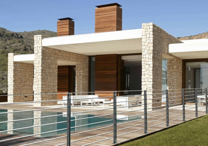 ein modernes Haus mit Schwimmbad und Gartenzaun aus Metall