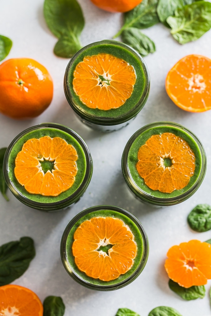 Smoothie mit Spinat selber machen, Vitaminbombe für frischen Start in den Tag, mit Orangenscheiben dekoriert 
