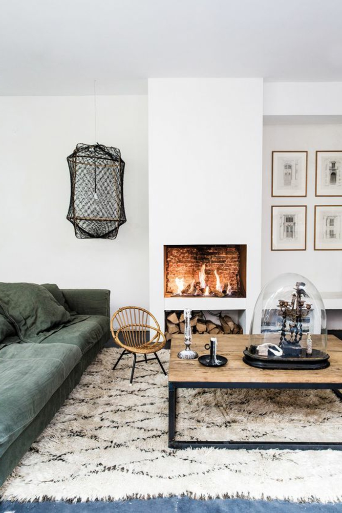 kamin-gemauert-grüne-couch-musterteppich-weiß-schwarz-couchtisch-massivholz-tischdeko-holzstuhl