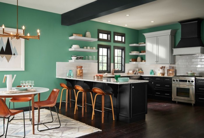 küche-wände-streichen-grün-led-licht-dunkler-laminatboden-weißer-musterteppich-weißer-rundtisch-holzstühle
