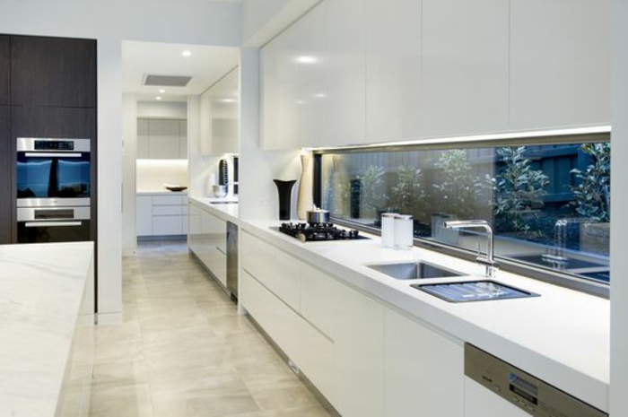 elegante küche in weiß mit glasrückwand mit pflanzen