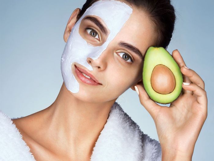 maske selbstgemacht hautmittel gegen unreine haut feuchtigkeitsmasken selber machen anti pickel maske peel of maske mit avocado frau halbes gesicht mit maske hält avocado
