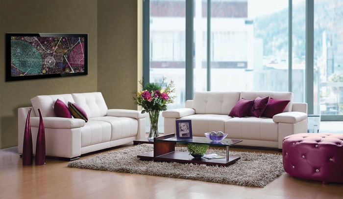 wohnung-modernes-Wohnzimmer-weißer-Sofa-Bild-lila-Dekokissen-helbrauner-Teppich-großer-Fenster-Kaffeetisch