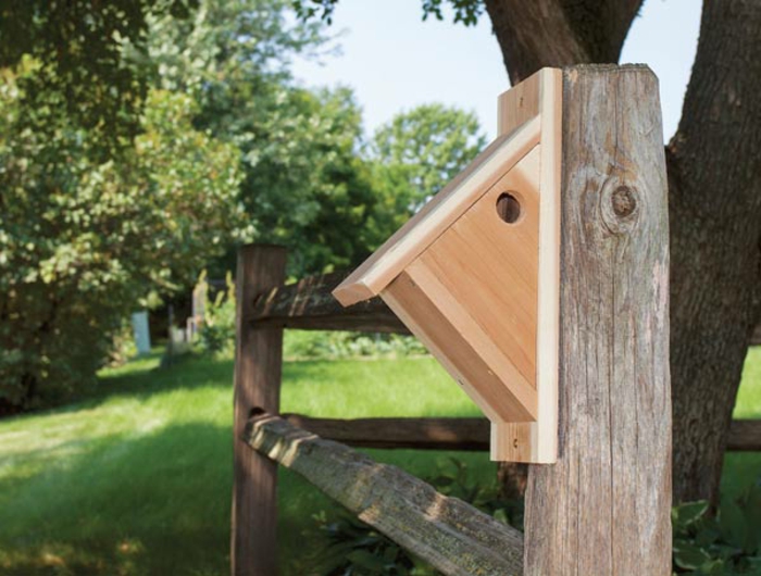 ein Holzhaus für Vögel in dreieckiger Form