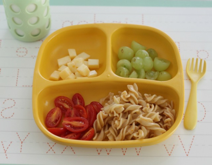 Lunch-Box mit Pasta, Cherrytomaten, Käse und Trauben