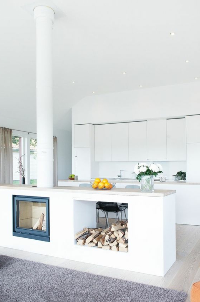 offene-küche-wohnzimmer-abtrennen-kamin-gemauert-feuerstelle-orangen-weiße-blumen-weiße-küchenfronten-teppich-grau-ikebana