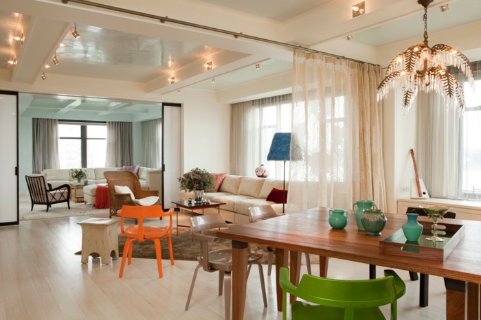 offene-küche-wohnzimmer-abtrennen-vorhang-holztisch-geüner-stuhl-teppich-creme-weiße-couch-oranger-stuhl-holzhocker
