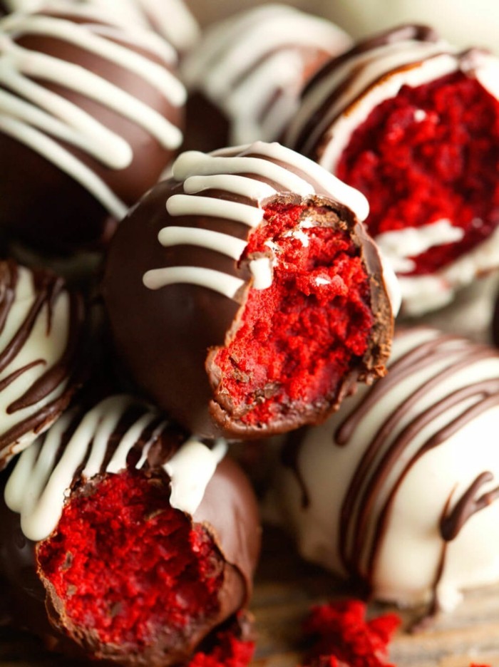 rote-lebensmittelfarbe-pralinen-kochen-schoenes-essen-samtkuchen-in-schokolade-umgeben-dunkle-schokolade-weisse-deko