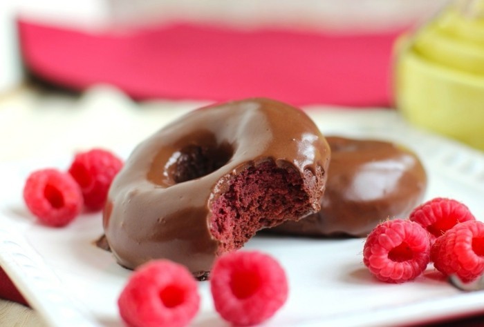 roter-kuchen-donuts-roter-teig-umgeben-von-dunkler-schokolade-himbeere-als-zusatz-beilage-schoen-serviert