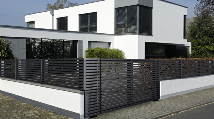 modernes Haus in Schwarz und Weiß mit Gartenzaun aus Metall
