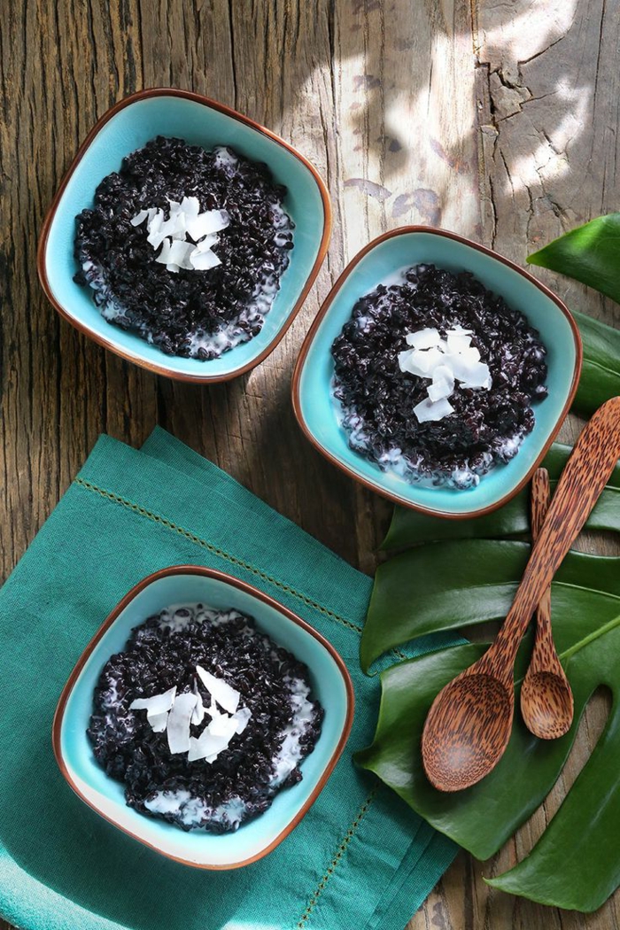 rezept mit schwarzem reis drei schüssel in türkis farbe milchreis schwarz hölzerne löffel kokosnuss