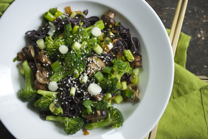schwarzen reis kochen grüne teller gestalten speise mit brokkoli zwiebeln mit stäbchen essen