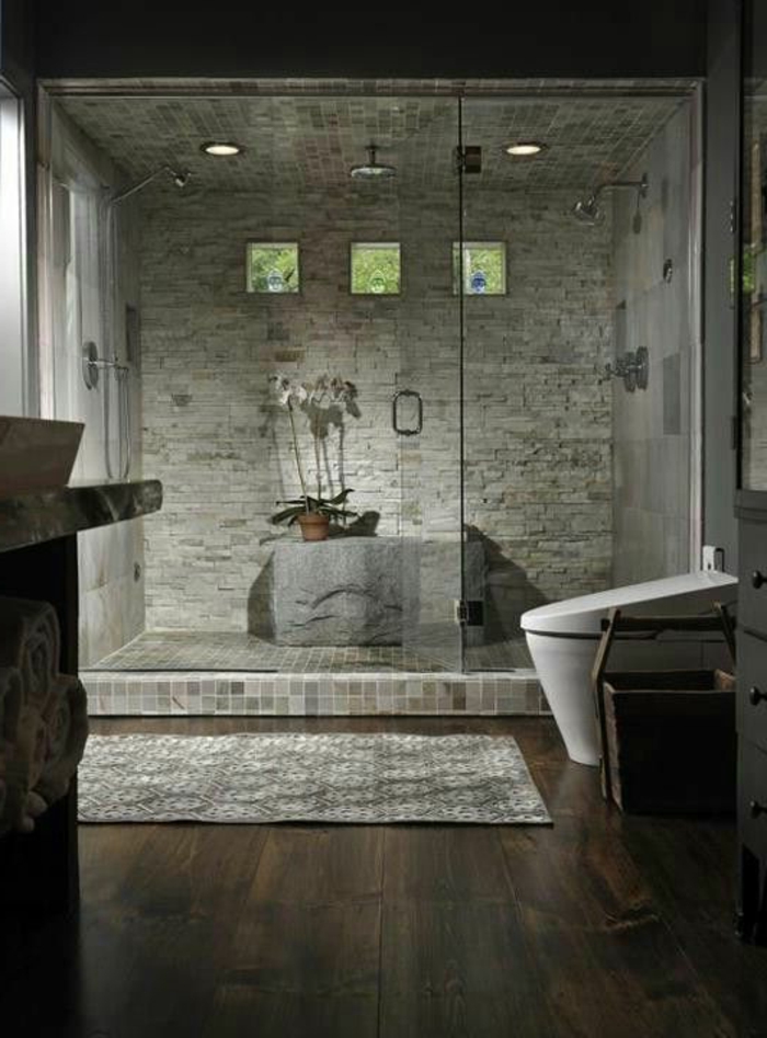 badezimmer mit naturstein und holz und duschkabinne