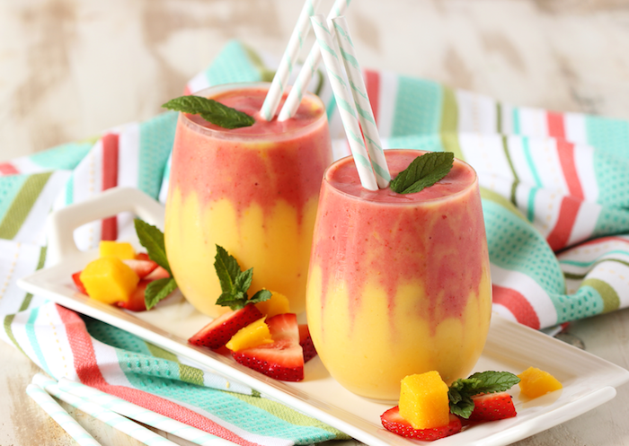 Smoothie Rezept mit Mango und Erdbeeren, dekoriert mit frischen Minzblättern, leckere Vitaminbombe 