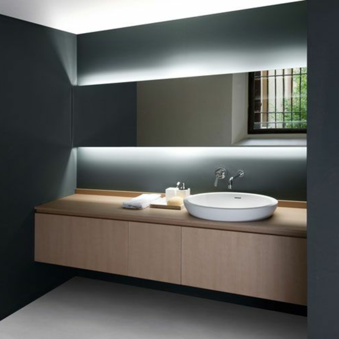 badezimmer in grau mit weißem waschbecken mit unterschrank und großem spiegel