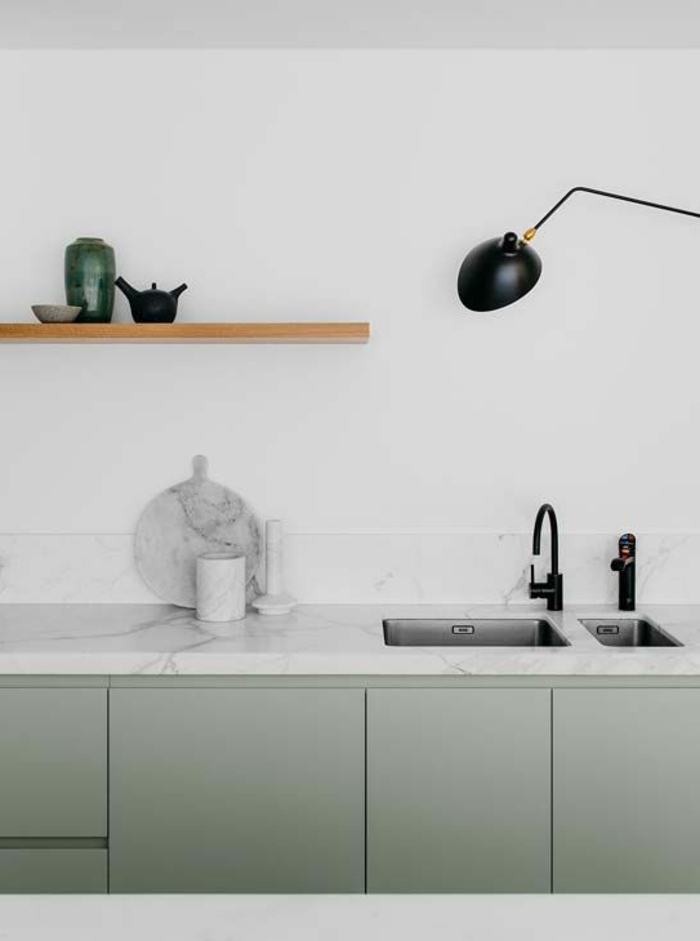 Küche mit minimalistischem Design, weiße Marmortischplatte, Marmorschneidebrett, grüne Küchenschranktüren