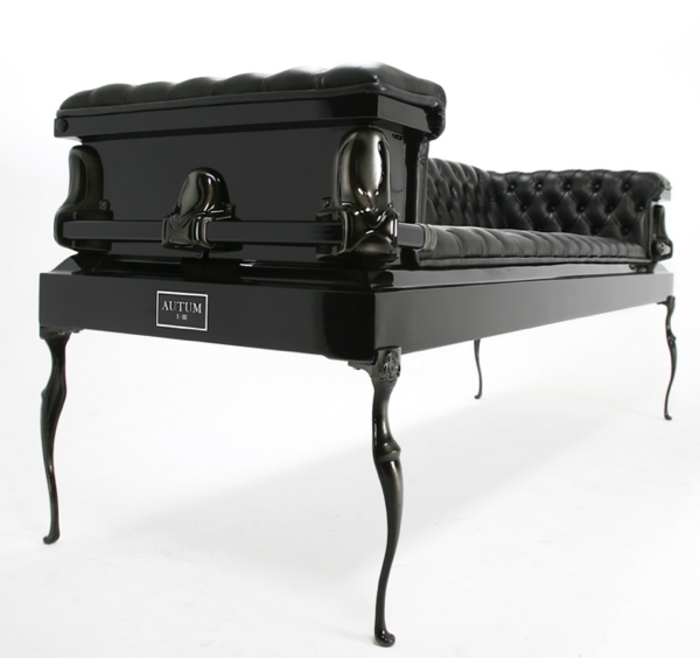 Gothic-Möbel: gotische Ledercouch in schwarzer Farbe mit schwarzen Holzbeinen und Metallornamenten