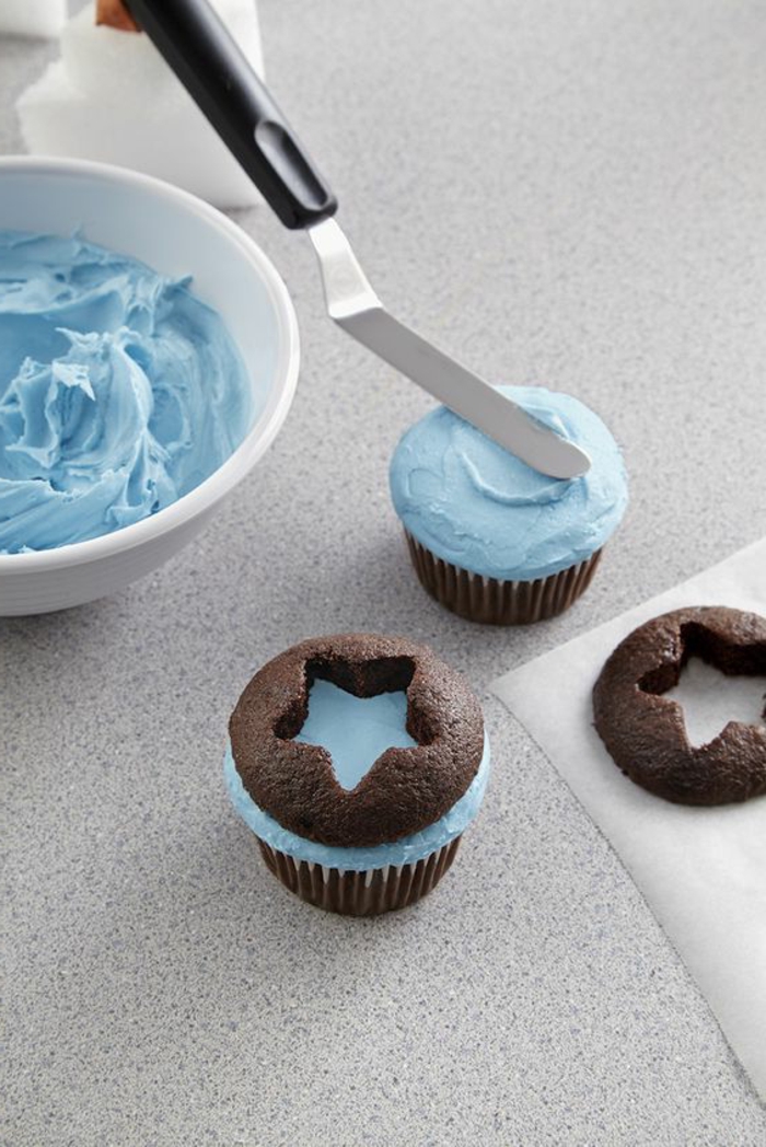 schoko-cupcakes mit blauer sahne verzieren